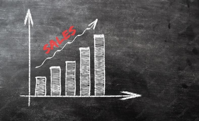 A hand-drawn bar chart on a blackboard showing rising sales figures, representing scrap metal price trends going up.