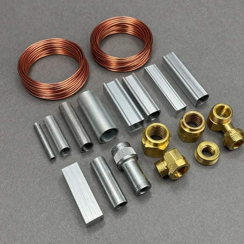 Various scrap metal pieces including copper wire, aluminium extrusion, brass fittings and steel laid out for identification at Prime Metal Recycling Melbourne