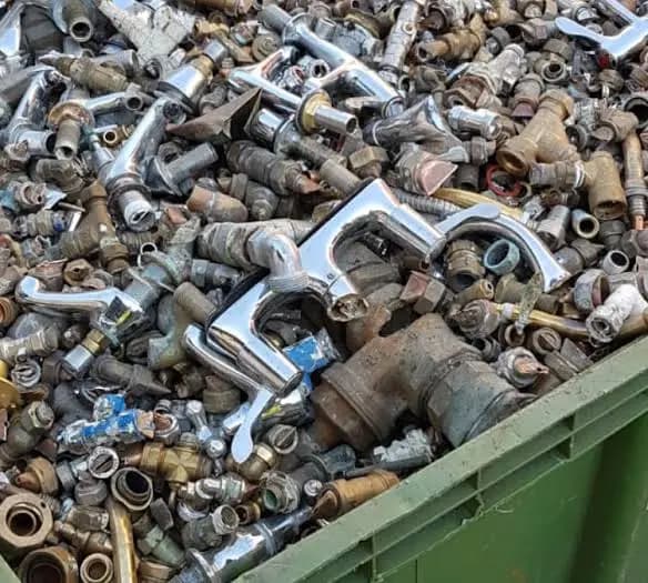 Mixed household scrap metal including brass fittings, plumbing parts and metal fixtures collected for recycling.